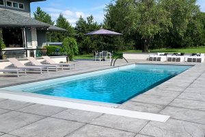 Sleek modern fiberglass pool with plenty of lounging area. Colored and stamped concrete to compliment the pool and furniture.